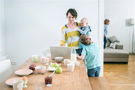 Mother with laptop and children in kitchen Photographie de stock - Premium Libres de Droits, Code: 6115-08149217