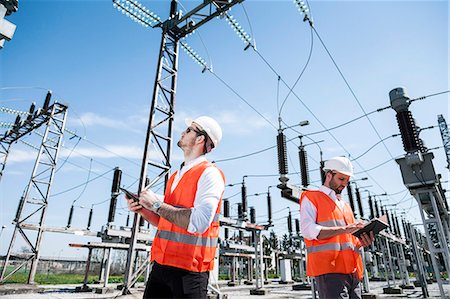 electric tower looking up - Engineers checking electricity substation Stock Photo - Premium Royalty-Free, Code: 6115-08149390