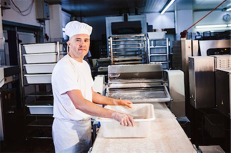 simsearch:6115-06778979,k - Confectioner preparing pastry dough in bakery Foto de stock - Sin royalties Premium, Código: 6115-08100499