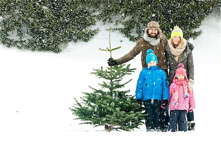 Family with two children stands with Christmas tree in snow-covered landscape, Bavaria, Germany Photographie de stock - Premium Libres de Droits, Code: 6115-08100635