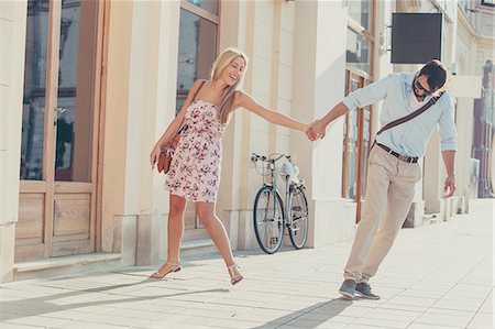 simsearch:6115-08101004,k - Happy young couple fooling around in town Fotografie stock - Premium Royalty-Free, Codice: 6115-08100942