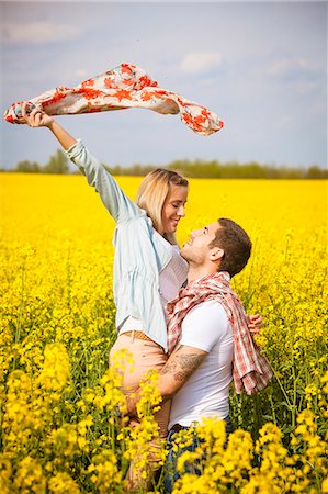 simsearch:6115-08101193,k - Young man embracing girlfriend in colza field, Tuscany, Italy Stock Photo - Premium Royalty-Free, Code: 6115-08101048