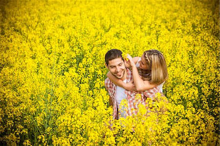 simsearch:6115-07539619,k - Happy young couple embracing in colza field, Tuscany, Italy Fotografie stock - Premium Royalty-Free, Codice: 6115-08101052