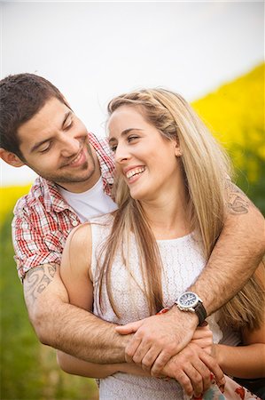 simsearch:6115-07539619,k - Happy young couple embracing in colza field, Tuscany, Italy Fotografie stock - Premium Royalty-Free, Codice: 6115-08101059