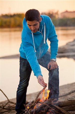 simsearch:6115-08101003,k - Young man arranging firewood at campfire, Osijek, Croatia Photographie de stock - Premium Libres de Droits, Code: 6115-08101004