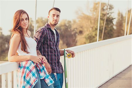 simsearch:6115-08101193,k - Young couple with skateboard relaxing on bridge Stock Photo - Premium Royalty-Free, Code: 6115-08101023