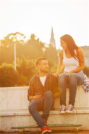 Young couple with skateboard relaxing at sunset Photographie de stock - Premium Libres de Droits, Code: 6115-08101022