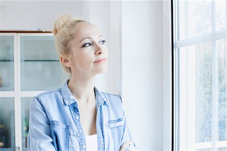 simsearch:6115-07282785,k - Blond woman looking through window Photographie de stock - Premium Libres de Droits, Code: 6115-08104899