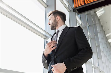 photo of fashion stage - Businessman adjusting tie in airport Stock Photo - Premium Royalty-Free, Code: 6115-08104947