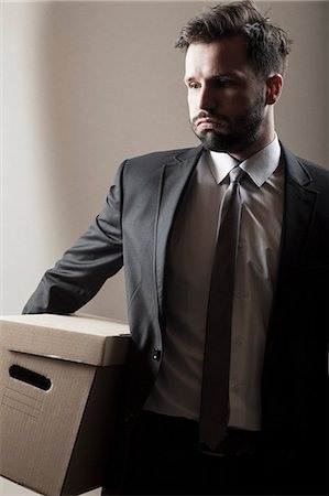 Businessman carrying cardboard box Stock Photo - Premium Royalty-Free, Code: 6115-08104957