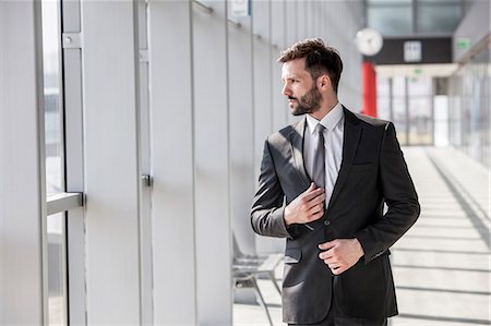 shirt businessman - Businessman adjusting tie in airport Stock Photo - Premium Royalty-Free, Code: 6115-08104954