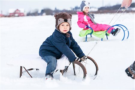 simsearch:6115-08104992,k - Two children on sled Foto de stock - Royalty Free Premium, Número: 6115-08104992