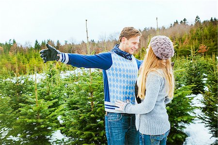Happy young couple standing in front of Christmas tree plantation Stock Photo - Premium Royalty-Free, Code: 6115-08104927