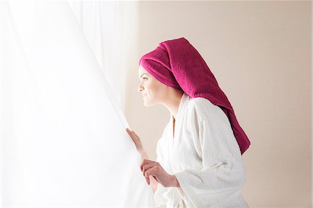 simsearch:6115-08105110,k - Young woman in bathrobe looking out of window Stock Photo - Premium Royalty-Free, Code: 6115-08105057