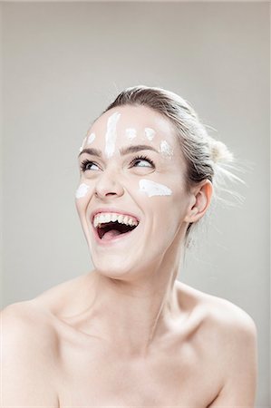 simsearch:6115-08105098,k - Young woman with streaks of lotion on face Foto de stock - Royalty Free Premium, Número: 6115-08105064