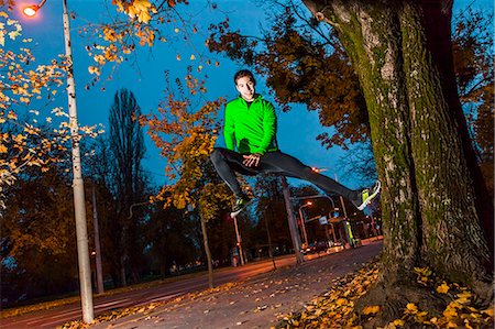 simsearch:6115-08239507,k - Male runner jumping in park Photographie de stock - Premium Libres de Droits, Code: 6115-08105039