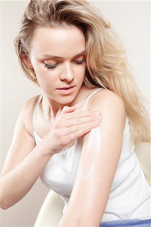 simsearch:6115-08105095,k - Young woman applying lotion on arms, close-up Stock Photo - Premium Royalty-Free, Code: 6115-08105117