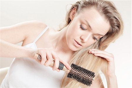 simsearch:6115-08105067,k - Young woman brushing her hair Foto de stock - Sin royalties Premium, Código: 6115-08105114