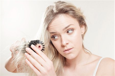 simsearch:6115-08105098,k - Young woman brushing her hair Foto de stock - Royalty Free Premium, Número: 6115-08105115