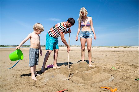 Parents and son making sandcastle on beach Stock Photo - Premium Royalty-Free, Code: 6115-08239257