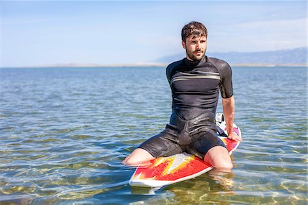 simsearch:6115-08239576,k - Surfer sitting on surfboard Stock Photo - Premium Royalty-Free, Code: 6115-08239231