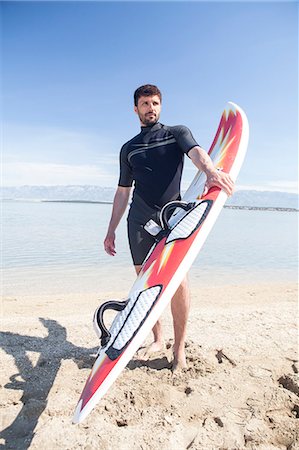 simsearch:6115-08239316,k - Male surfer on beach Foto de stock - Sin royalties Premium, Código: 6115-08239239