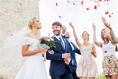 simsearch:6115-08239477,k - Guests throwing rose petals on bride and groom Stock Photo - Premium Royalty-Free, Code: 6115-08239361