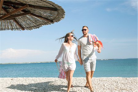 simsearch:6115-07539705,k - Young couple walking on beach Photographie de stock - Premium Libres de Droits, Code: 6115-08239300