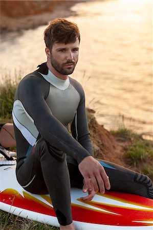 simsearch:6115-08239576,k - Surfer sits on surfboard Stock Photo - Premium Royalty-Free, Code: 6115-08239338