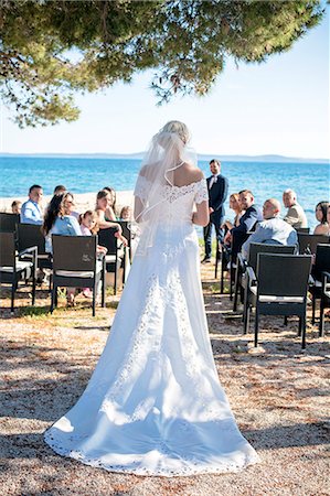 simsearch:6115-08239477,k - Rear view of bride at wedding ceremony on beach Stock Photo - Premium Royalty-Free, Code: 6115-08239446