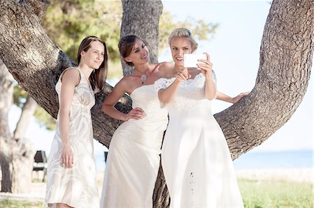 Bride and bridesmaids taking photo of themselves Stock Photo - Premium Royalty-Free, Code: 6115-08239465