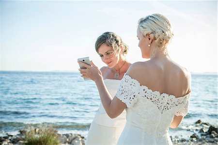 simsearch:6115-08239477,k - Bride and bridesmaid text messaging outdoors Stock Photo - Premium Royalty-Free, Code: 6115-08239480