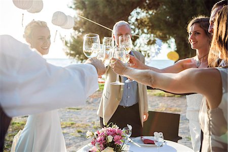 Drinking champagne at wedding reception on the beach Stock Photo - Premium Royalty-Free, Code: 6115-08239487