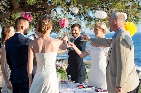 simsearch:6115-08239440,k - Drinking champagne at wedding reception on the beach Foto de stock - Royalty Free Premium, Número: 6115-08239486