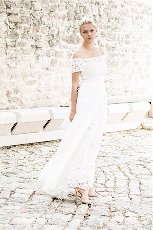 simsearch:6115-07109837,k - Bride in wedding dress stands in front of church Stock Photo - Premium Royalty-Free, Code: 6115-08239400