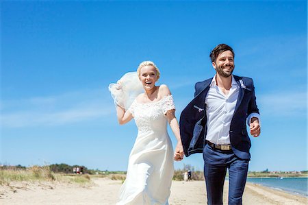 Bride and bridegroom on beach having fun Stock Photo - Premium Royalty-Free, Code: 6115-08239428