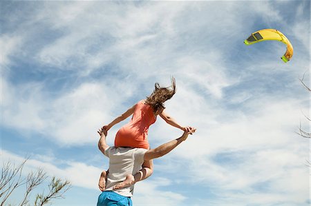 simsearch:6115-08239587,k - Young woman sitting on shoulder of her boyfriend Photographie de stock - Premium Libres de Droits, Code: 6115-08239547