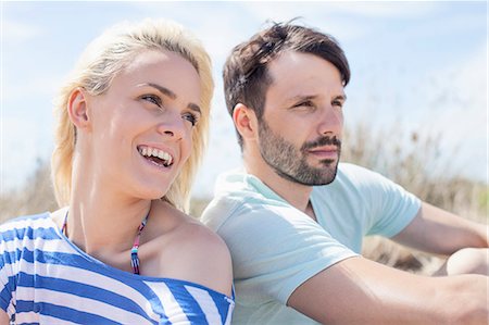 simsearch:6115-08239578,k - Young couple sitting side by side on beach Stock Photo - Premium Royalty-Free, Code: 6115-08239563