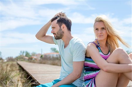 simsearch:6115-08239929,k - Portrait of young couple on beach looking sad Stock Photo - Premium Royalty-Free, Code: 6115-08239569