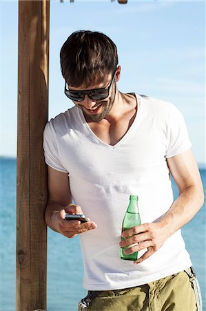 simsearch:6115-08239578,k - Man with sunglasses using mobile phone Stock Photo - Premium Royalty-Free, Code: 6115-08239579