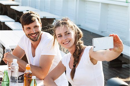 selfie drinking - Young couple taking a self portrait in beach bar Stock Photo - Premium Royalty-Free, Code: 6115-08239582