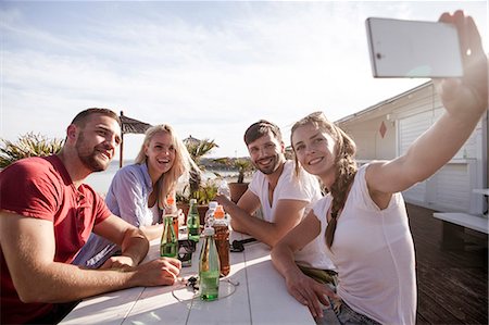 simsearch:6115-08239587,k - Group of friends taking a self portrait in beach bar Photographie de stock - Premium Libres de Droits, Code: 6115-08239586