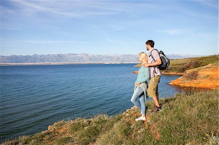 simsearch:6115-08239576,k - Young couple on cliff looking at sea Stock Photo - Premium Royalty-Free, Code: 6115-08239593