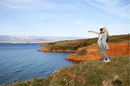 simsearch:6115-08239578,k - Young couple on cliff looking at sea Stock Photo - Premium Royalty-Free, Code: 6115-08239599