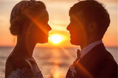 simsearch:6115-08239440,k - Bride and bridegroom face to face against sunset Foto de stock - Royalty Free Premium, Número: 6115-08239505