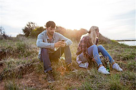 simsearch:6115-08239587,k - Young couple with MP3 player sitting outdoors Photographie de stock - Premium Libres de Droits, Code: 6115-08239640