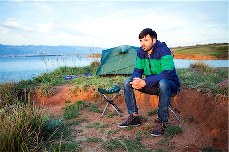 simsearch:6115-08239576,k - Young man at campsite day dreaming Stock Photo - Premium Royalty-Free, Code: 6115-08239647