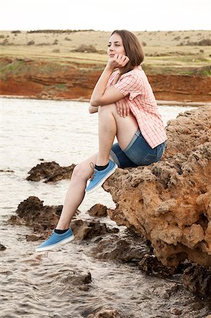 simsearch:6115-08239576,k - Young woman on water's edge day dreaming Stock Photo - Premium Royalty-Free, Code: 6115-08239614