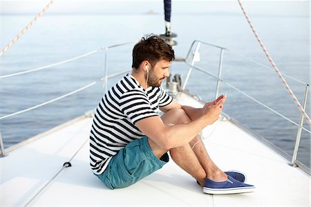 sailing music - Man listening to music on sailboat, Adriatic Sea Stock Photo - Premium Royalty-Free, Code: 6115-08239793