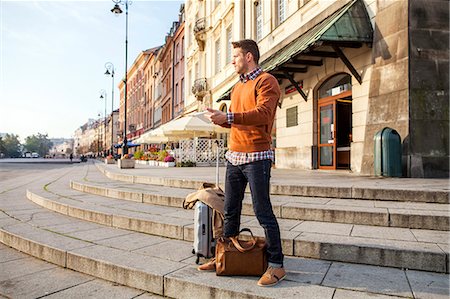 Man on a city break using digital tablet Stock Photo - Premium Royalty-Free, Code: 6115-08416245